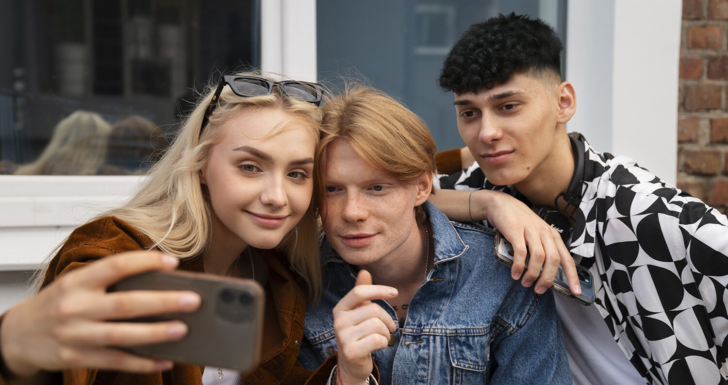 Drei junge Leute, die ein Selfie mit einem Smartphone miteinander machen